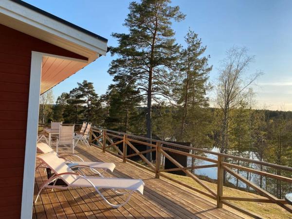 Na zdjęciu widoczny jest obiekt Trevligt fritidshus med stor terrasse mot sjöen położony w mieście Skillingsfors.