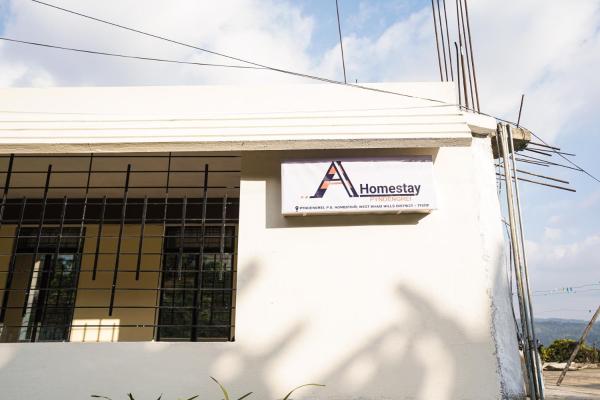 The photo shows the AI Homestay Nongstoin located in the city of Nongstoin.
