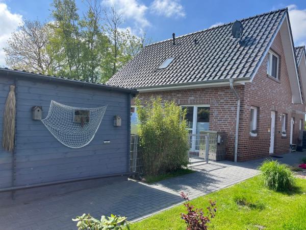 The photo shows the Haus Nordseeliebe mit Außensauna, Outdoor Dusche und Wallbox located in the city of Dornum.
