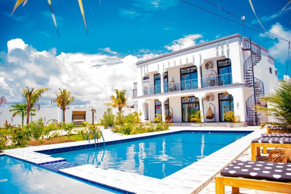 The photo shows the Coral Cove Apartments located in the city of Kiganga.