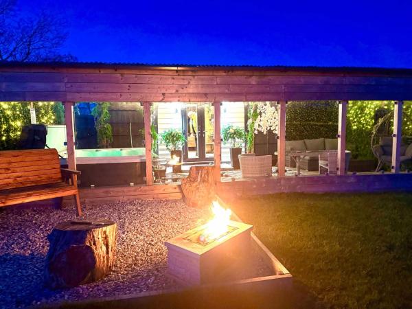 På billedet ses objektet Barlosh kiloch Tpod Lodge, Ayrshire, elec jacuzzi, bbq, Firepit, indooroutdoor terrace with outdoor sofa, egg chair,dinning country views,etc very spacious inside and out beliggende i byen Cumnock.