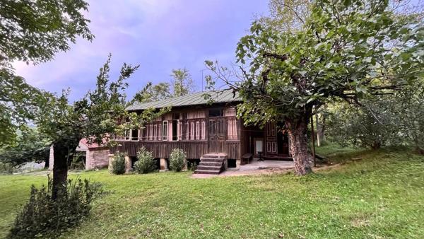 The photo shows the Une maison traditionnelle de Georgie located in the city of Tkibulges.