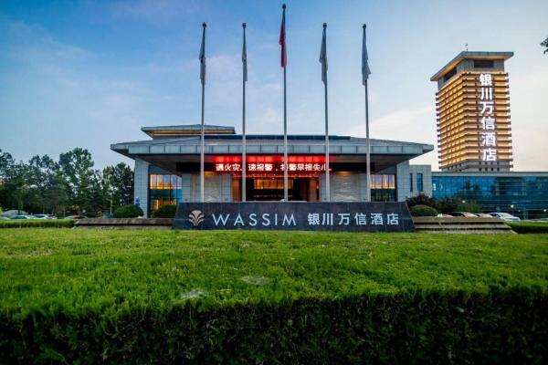 The photo shows the 银川河东机场万信瑞铂酒店 located in the city of Maliantai.