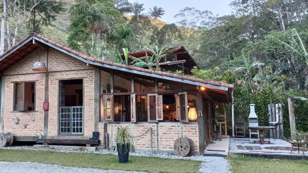 The photo shows the Casa com riacho e jardim particular próximo ao rio located in the city of Córrego da Luz.