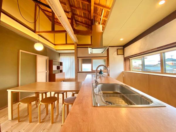 Na fotografii je vidět objekt 広い縁側とタタミの部屋に天井吹抜けのオープンキッチンがある一軒家でキッチンやバスルームは最新設備 nacházející se ve městě Komoro.