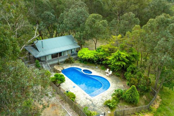 The photo shows the Country Charm Cottage with Pool and Forest Views located in the city of Wonga Park.