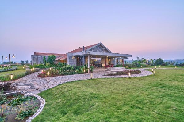 The photo shows the SaffronStays Ashfield - 5BHK Eco-Farmhouse with Pools, Jacuzzi, Lawn & Games Room located in the city of Vani.