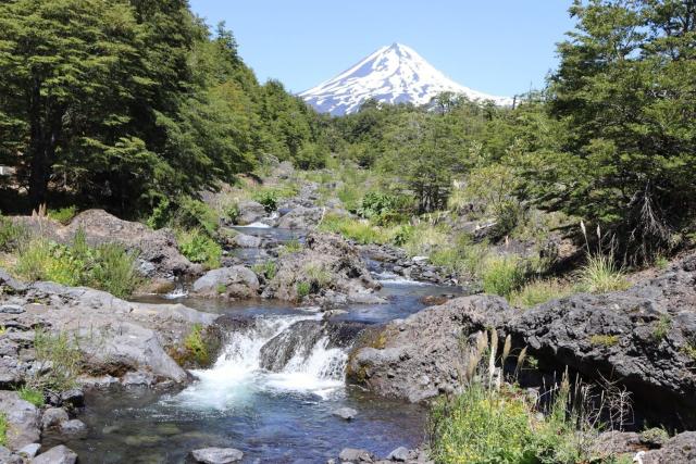 Vista al volcán con tinaja y río en Conguillío