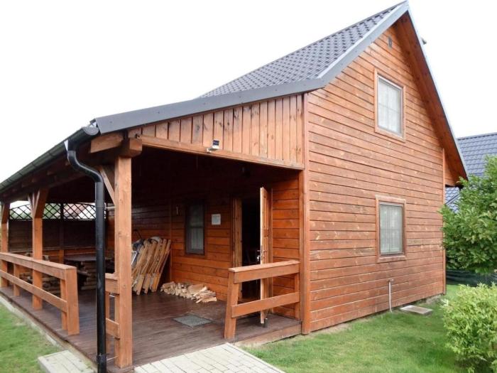 Holzhütte mit überdachter Terrasse und Garten