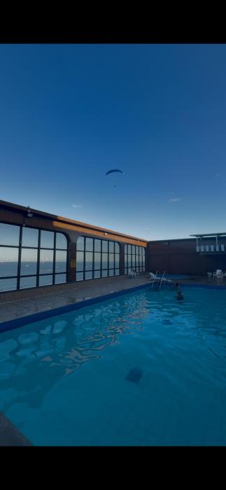 AP com prédio de frente para o mar e piscina na cobertura