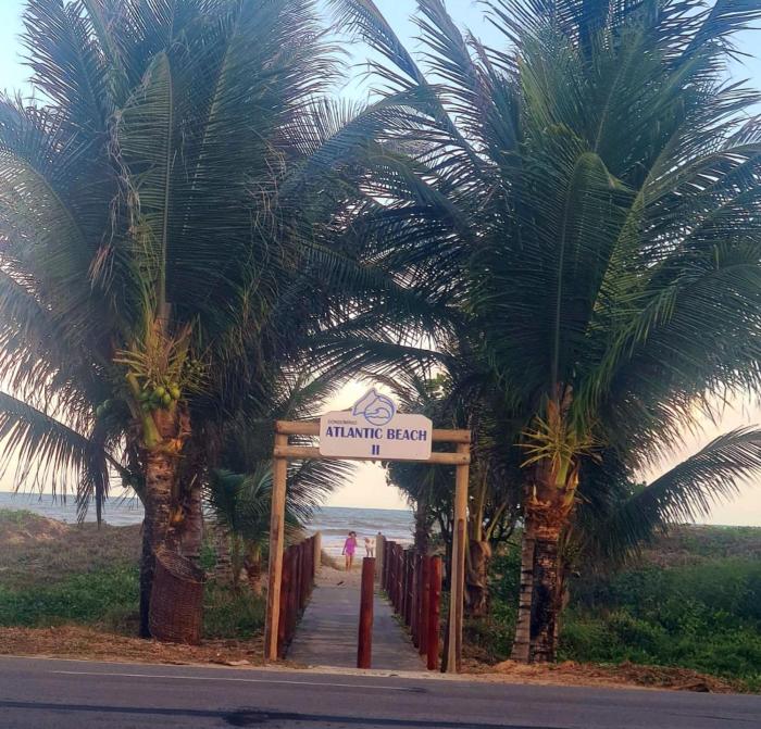 Casa cinza em frente à praia em condominio