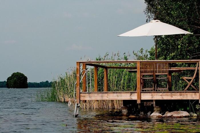 Lakefront house with beach, jetty, and rowing boat