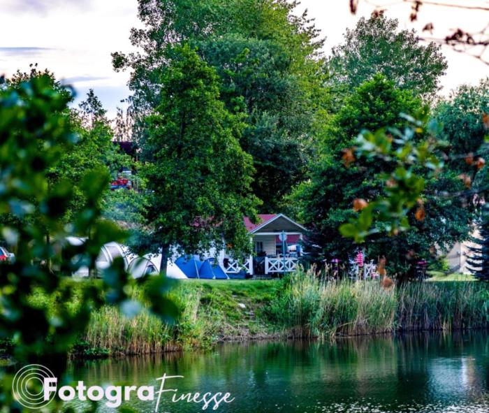 Forteca, rustykalne drewniane domki nad brzegiem stawu, łazienki współdzielone