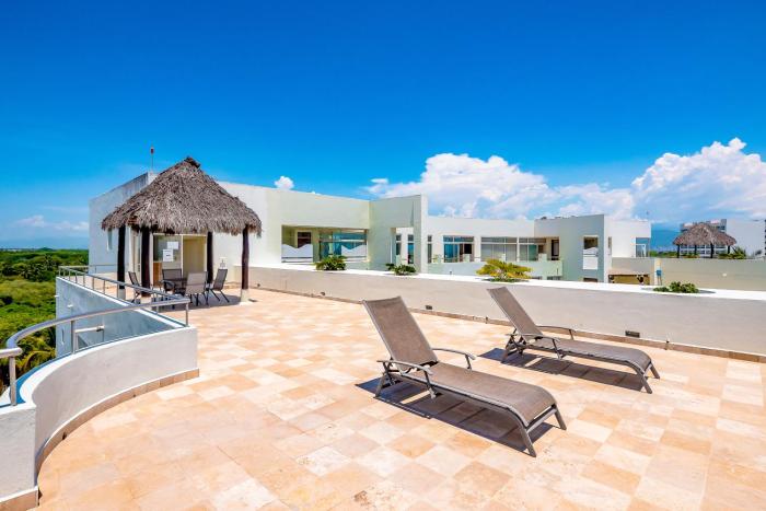 Ocean-view condo with pools, roof deck, lounge, private balcony, & AC