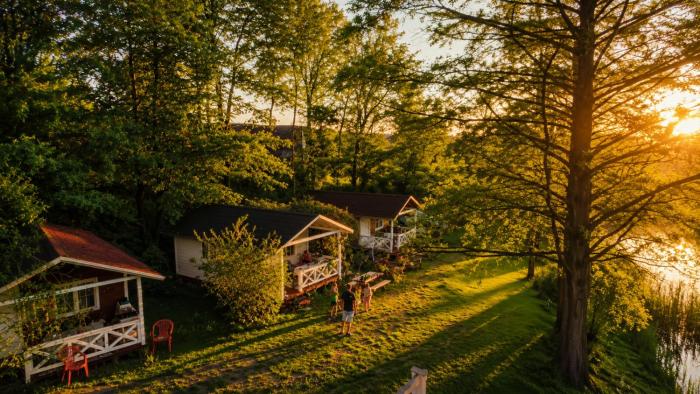 Forteca, rustykalne drewniane domki nad brzegiem stawu, łazienki współdzielone