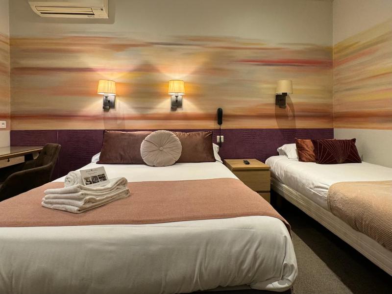 Triple Room with window overlooking a painted wall image 3