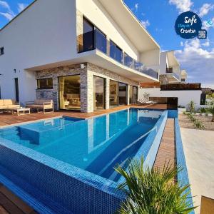 Villa Ramarin 1 with heated pool, jacuzzi and sauna by the sea in Rogoznica