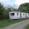 caravan nestled away amongst trees on edge of farm yard - Bala