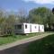 caravan nestled away amongst trees on edge of farm yard - Bala