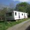 caravan nestled away amongst trees on edge of farm yard - Bala