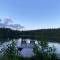 Mökki järven rannalla mäntymetsässä