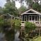 Thatched Home by Pond in Holiday Park