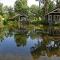 Thatched Home by Pond in Holiday Park