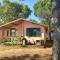 Holzchalet mit überdachter Veranda und Terrassenmöbeln auf einem schönen Campingplatz