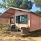 Holzchalet mit überdachter Veranda und Terrassenmöbeln auf einem schönen Campingplatz