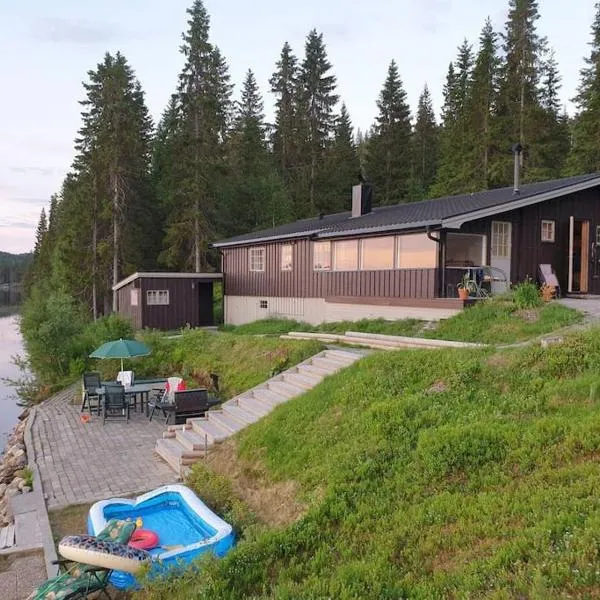 Idyllic lakeside cabin with private beach and boat, hôtel à Vassli