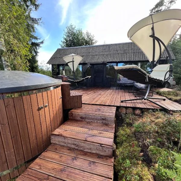 Black house in the forest with Hot Tube and Home theater for movies, hotel in Līči
