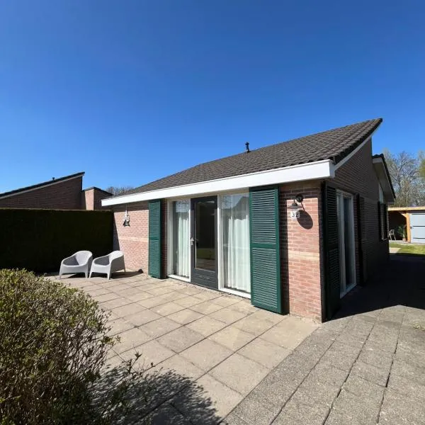 Knusse bungalow met omheinde tuin met veranda, hótel í Tzummarum