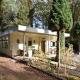 A detached bungalow with outdoor fireplace, covered terrace and pond in a forest plot