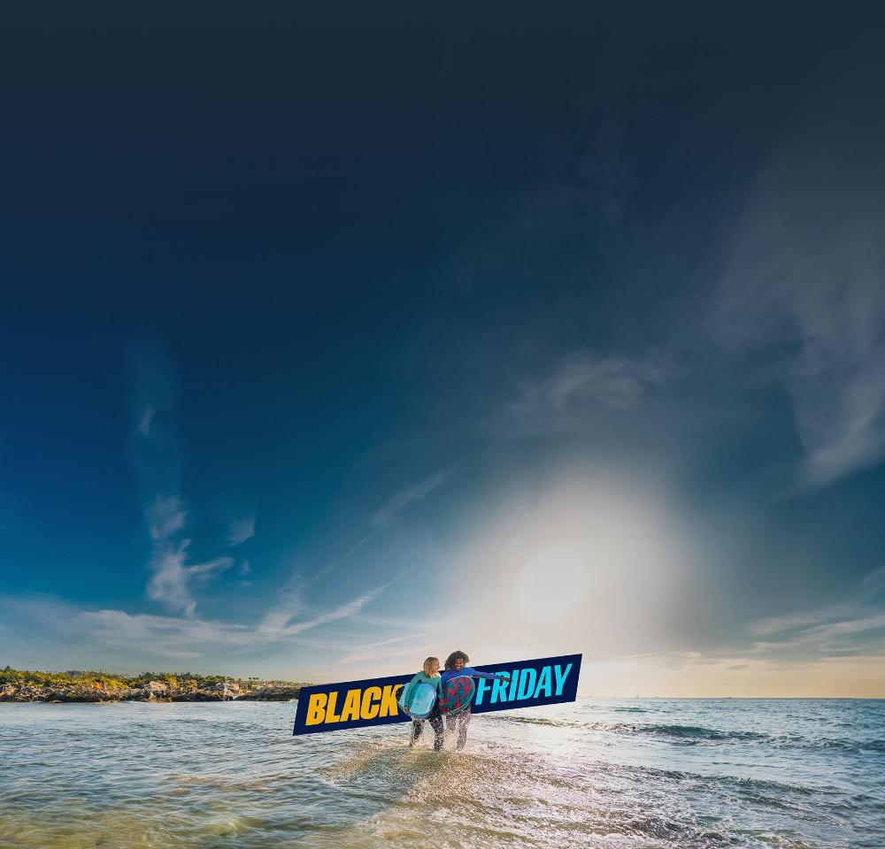 Un logo del Black Friday y dos personas con tablas de bodysurf en la playa