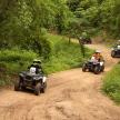 a group of people riding atvs down a dirt road