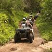 a group of people riding on a four wheeler on a dirt trail