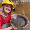 a woman wearing a hard hat holding a bucket