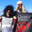 a man and a woman holding a game of game of thrones sign