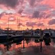 a group of boats docked in a marina at sunset