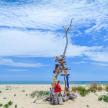 a person standing next to a wooden structure on the beach