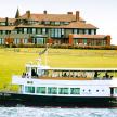 a boat on the water in front of a large house