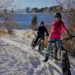 two people riding bikes in the snow