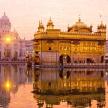 a golden temple with its reflection in the water