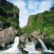 a stream of water flowing through a mountain with rocks