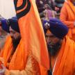 a group of men wearing orange turbans holding a flag