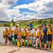 a group of people in life jackets standing next to a raft