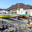 a group of people standing on a beach with boats