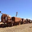 an old train sitting on the tracks in the desert