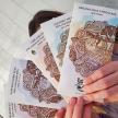 a woman holding three cards in her hands