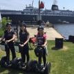 three girls riding on segways in front of a cruise ship